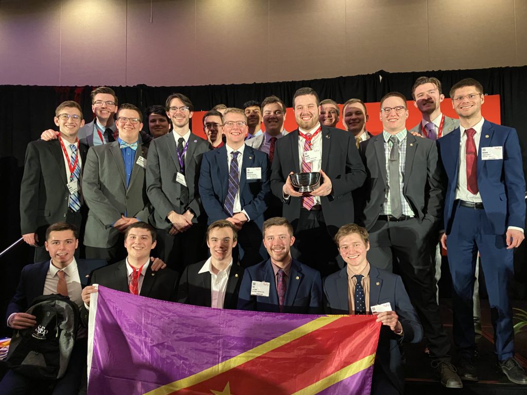 SigEp UNI brothers posing with the SigEp Flag at Carlson Leadership Academy